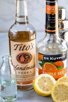 the ingredients to make an alcoholic cocktail include oranges, lemons and vodka bottles