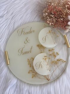 two plates with flowers on them sitting on a white furnishing next to a dried flower