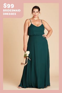 a woman in a long green dress holding a flower and posing for the camera with her hands on her hips