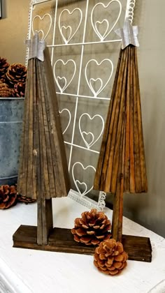 some pine cones are sitting on a table next to two wooden umbrellas with hearts drawn on them