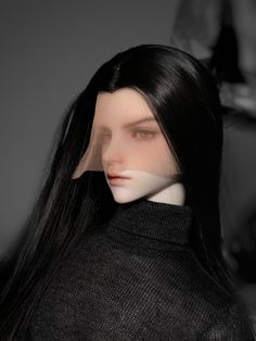 a mannequin with long black hair wearing a turtle neck sweater and looking at the camera