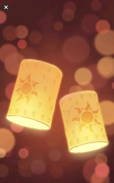 two yellow lamps sitting next to each other on top of a table covered in lights