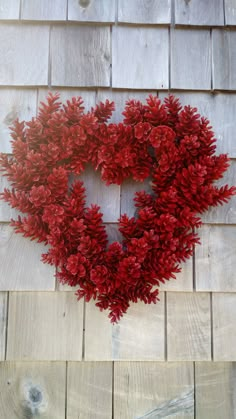 a heart shaped wreath on the side of a wooden wall next to a brick building