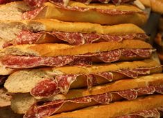 many slices of bread stacked on top of each other with salami and cheese in the middle