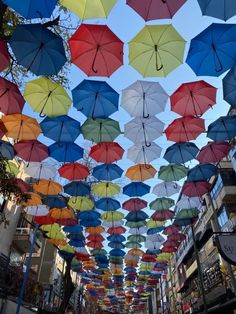 many colorful umbrellas are hanging from the ceiling