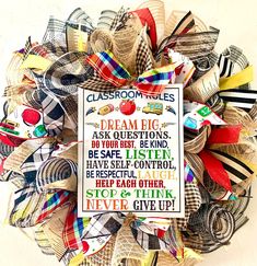 a wreath made out of newspaper strips and ribbons with the words classroom rules written on it