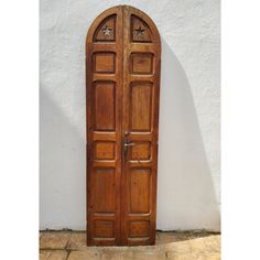 an old wooden door on the side of a white building with star shaped window frames