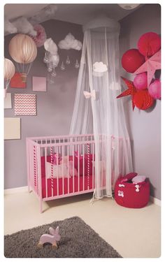 a baby's room with pink and white decor, including a crib bed