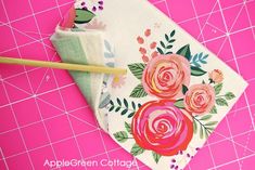 a pair of chopsticks sitting on top of a piece of cloth with flowers