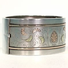 Whenever I talk about antique jewelry, I like to refer to it as 'wearable art', no where is this more clearly seen than with English Victorian silver jewelry. Each bangle, collar, earring, locket, was lovingly and elaborately made, with gold overlay, with fantastic engraving, with embossed designs, one piece more stunningly detailed than the next. This fabulous bangle was hand crafted in England around 1880. It has a lovely soft bloomed finish and is decorated with richly detailed engraving and Formal Cuff Bracelet With Intricate Design, Antique Cuff Bracelet With Intricate Design For Formal Occasions, Heirloom Cuff Bracelet With Intricate Design For Formal Occasions, Ceremonial Vintage Jewelry With Historical Design, Vintage Ceremonial Jewelry With Historical Design, Victorian Cuff Bracelet With Intricate Design For Formal Events, Heirloom Engraved Ceremonial Jewelry, Heirloom Ceremonial Engraved Jewelry, Heirloom Engraved Jewelry Bracelet