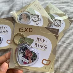 two key rings with pictures on them are being held by someone