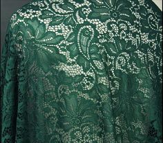 a green lace fabric with white flowers on it