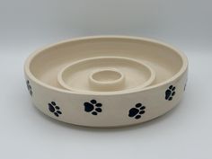 a white bowl with black paw prints on it