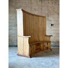 an old wooden bed frame with drawers on the bottom and sides, in front of a brick wall