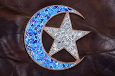 a star and moon made out of glass mosaics on a brown leather background,