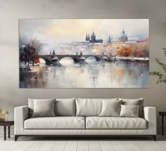 a large painting hanging on the wall above a couch in a room with white walls