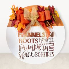 a white plate with an orange bow and words on it that say pumpkin spice bonfires