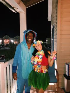 a man and woman in costumes standing on a porch