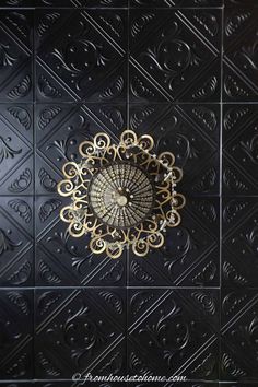 the ceiling is made up of black and gold tiles with an intricate design on it