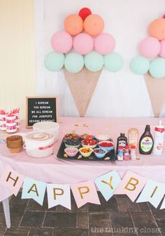 a table topped with lots of food and balloons