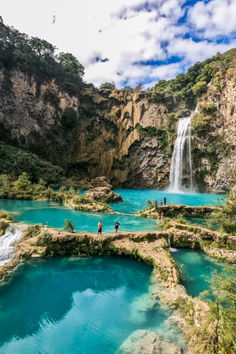 people are standing at the base of a waterfall in plitunu national park