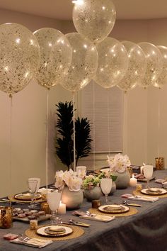 the table is set with balloons and place settings for an elegant dinner or party celebration