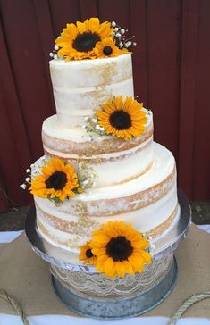 a wedding cake with sunflowers on top