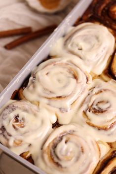 a pan filled with cinnamon rolls covered in icing