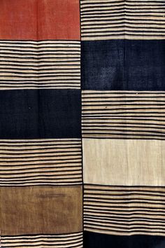 a piece of cloth with different colors and patterns on it's sides, including red, black, tan, and white stripes