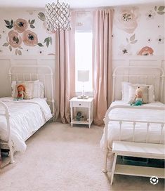 two white beds sitting next to each other on top of a bed in a bedroom