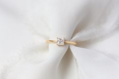 a diamond ring sitting on top of a white cloth