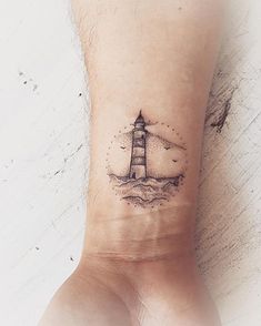 a small lighthouse tattoo on the wrist