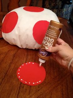 someone is painting the inside of a mushroom pillow with red and white polka dots on it