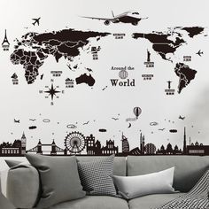 a living room with a couch and wall decals on the walls that say around the world