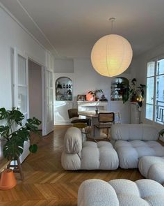 a living room filled with furniture next to a window covered in white blankets and pillows