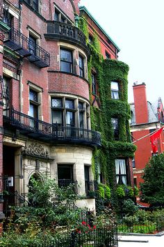 an apartment building with ivy growing on it's side