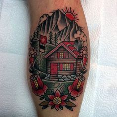 a tattoo on the leg of a person with a house and mountains in the background