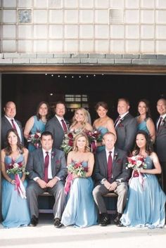 a large group of people in formal wear posing for a photo outside the door of a building