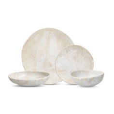 three white marble plates and two bowls on a white background, with one plate in the middle