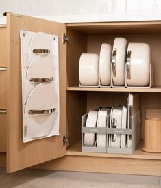 a cabinet filled with white dishes and plates