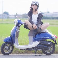 a woman sitting on top of a blue scooter