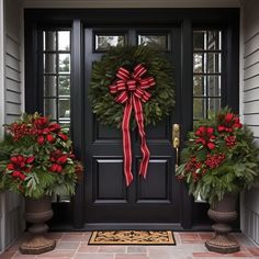 two christmas wreaths on the front door of a house