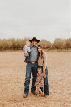 a man, woman and child are standing in the dirt