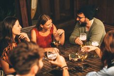 several people sitting around a table drinking wine