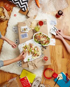 several people are eating food on the floor