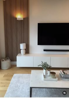 a flat screen tv sitting on top of a white entertainment center in a living room