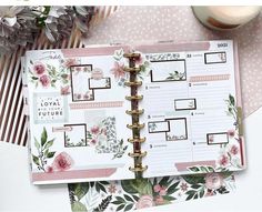 an open planner book sitting on top of a table next to some flowers and candles