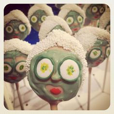 green and white cake pops with faces on them