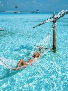 a woman laying on a hammock in the ocean