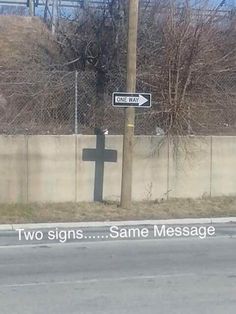 a street sign on the side of a road next to a fenced in area